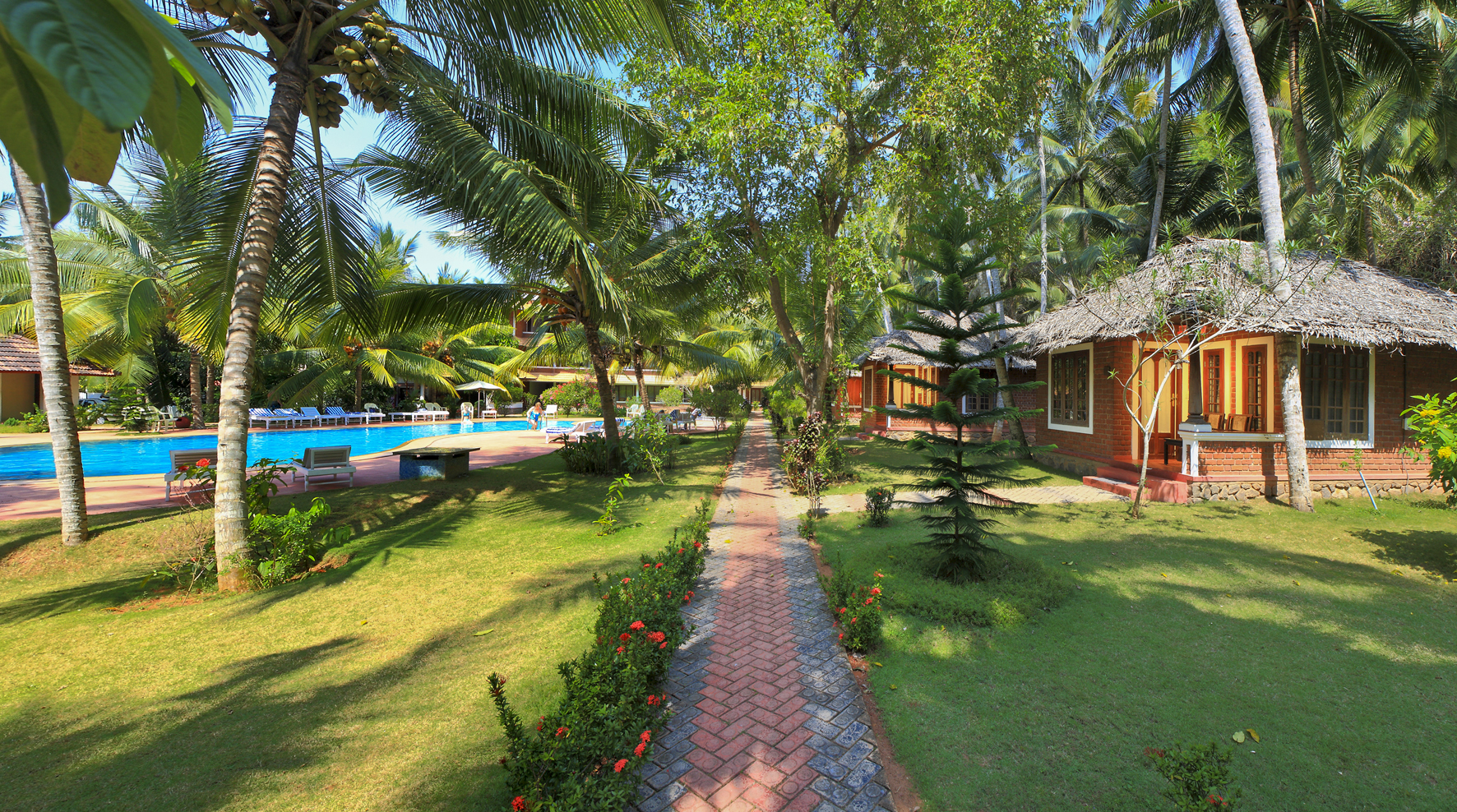 Garden pathway leading past cottages towards the swimming pool