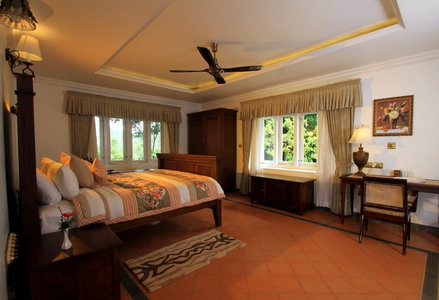 Bungalow bedroom with teak furniture and garden-facing windows