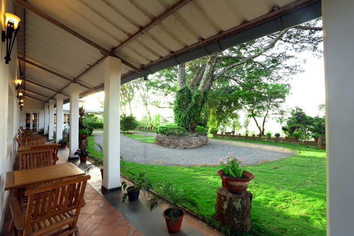 Bungalow verandah with planters' chairs looking onto the garden