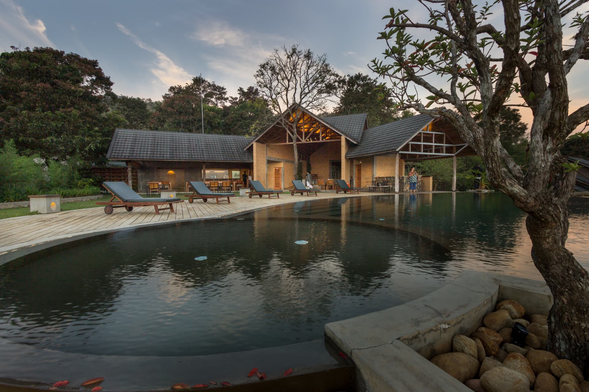 Pool deck, loungers and lamplit pavilions at twilight, Prakriti Shakti CGH Earth Panchalimedu