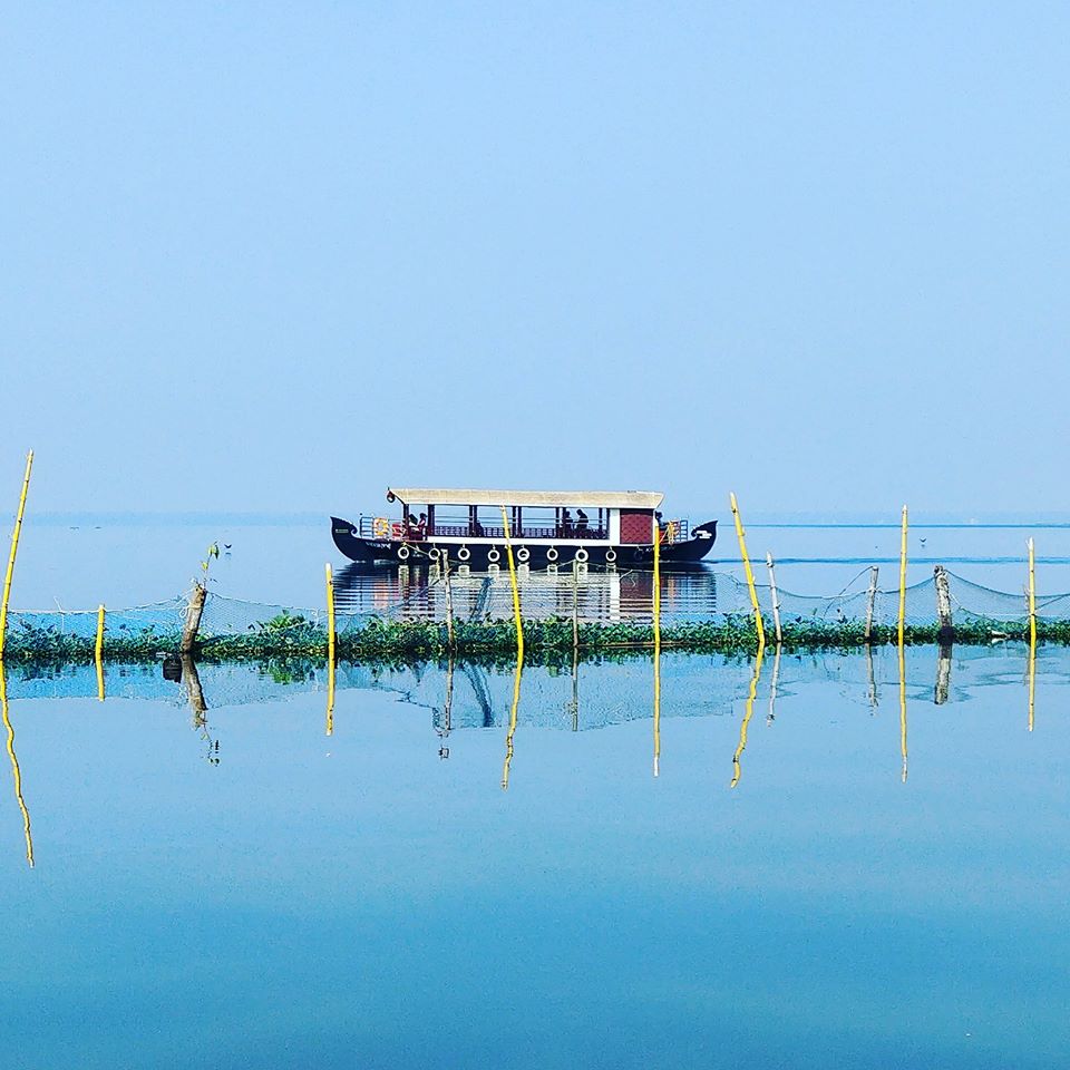 Houseboat on the calm blue backwaters seen from the resort grounds