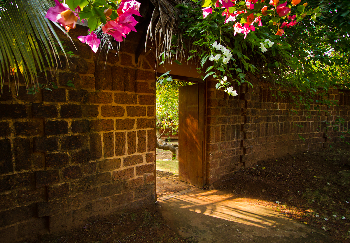 SwaSwara, CGH Earth — bougainvillea over a laterite doorway