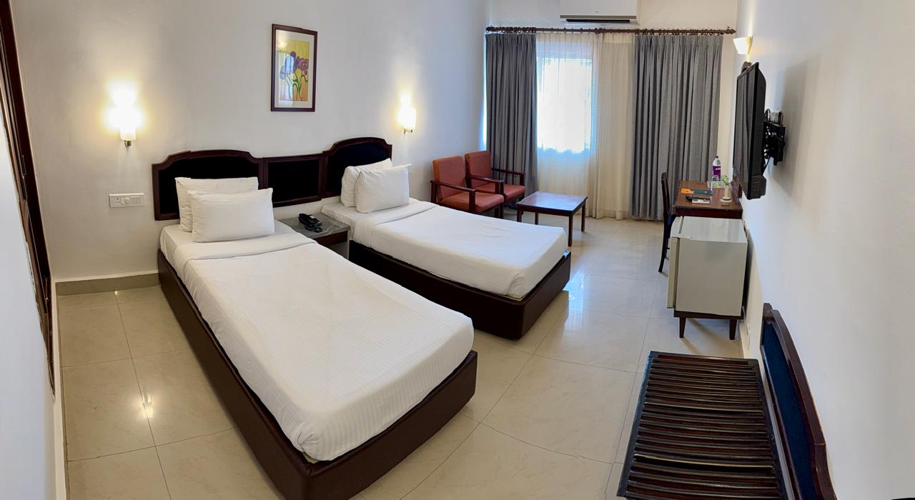 Deluxe Room at Abad Fort with twin beds and writing desk