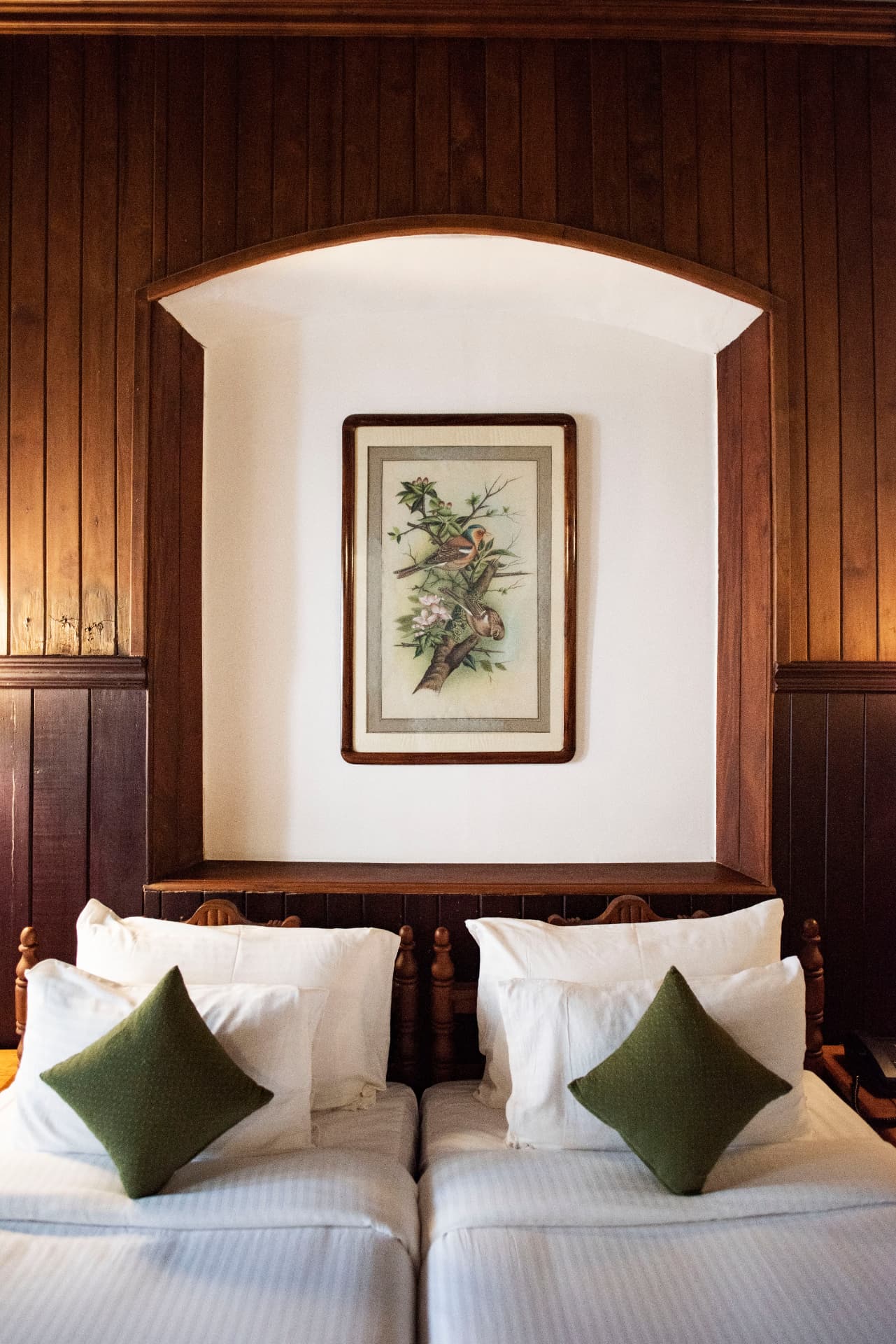 Twin beds beneath a framed botanical print