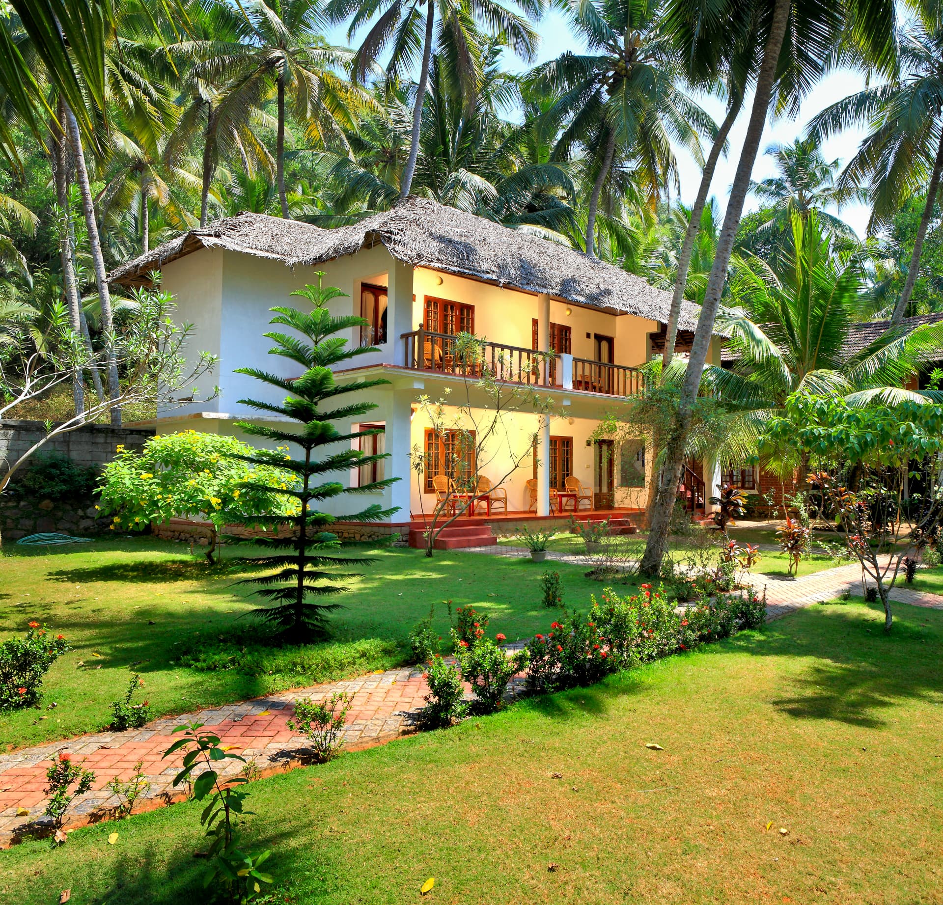 Two-storey guest block with balconies among coconut palms