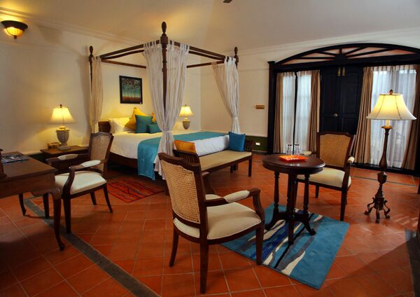 Heritage suite with carved four-poster bed and cane armchairs