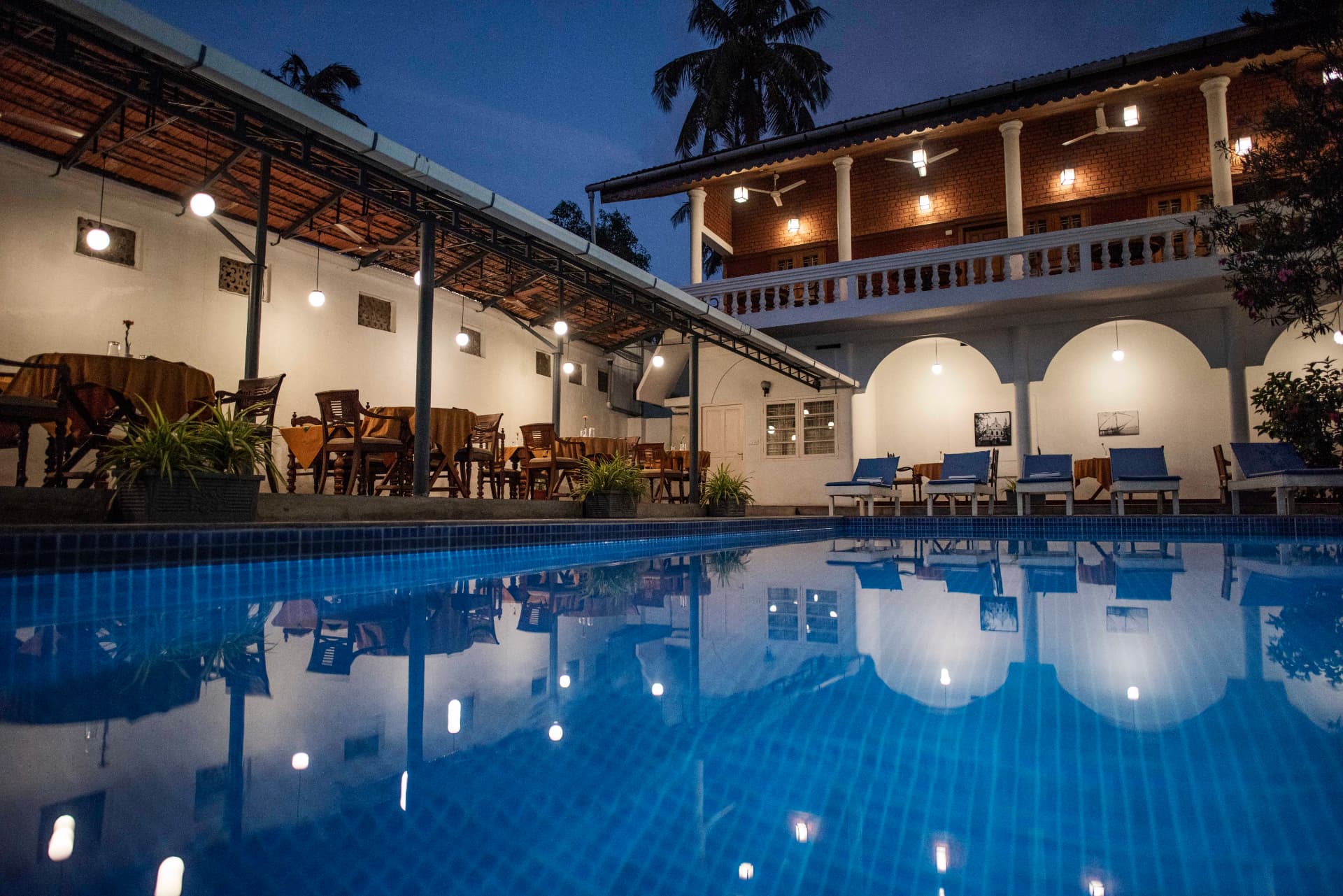Poolside dining terrace lit at dusk
