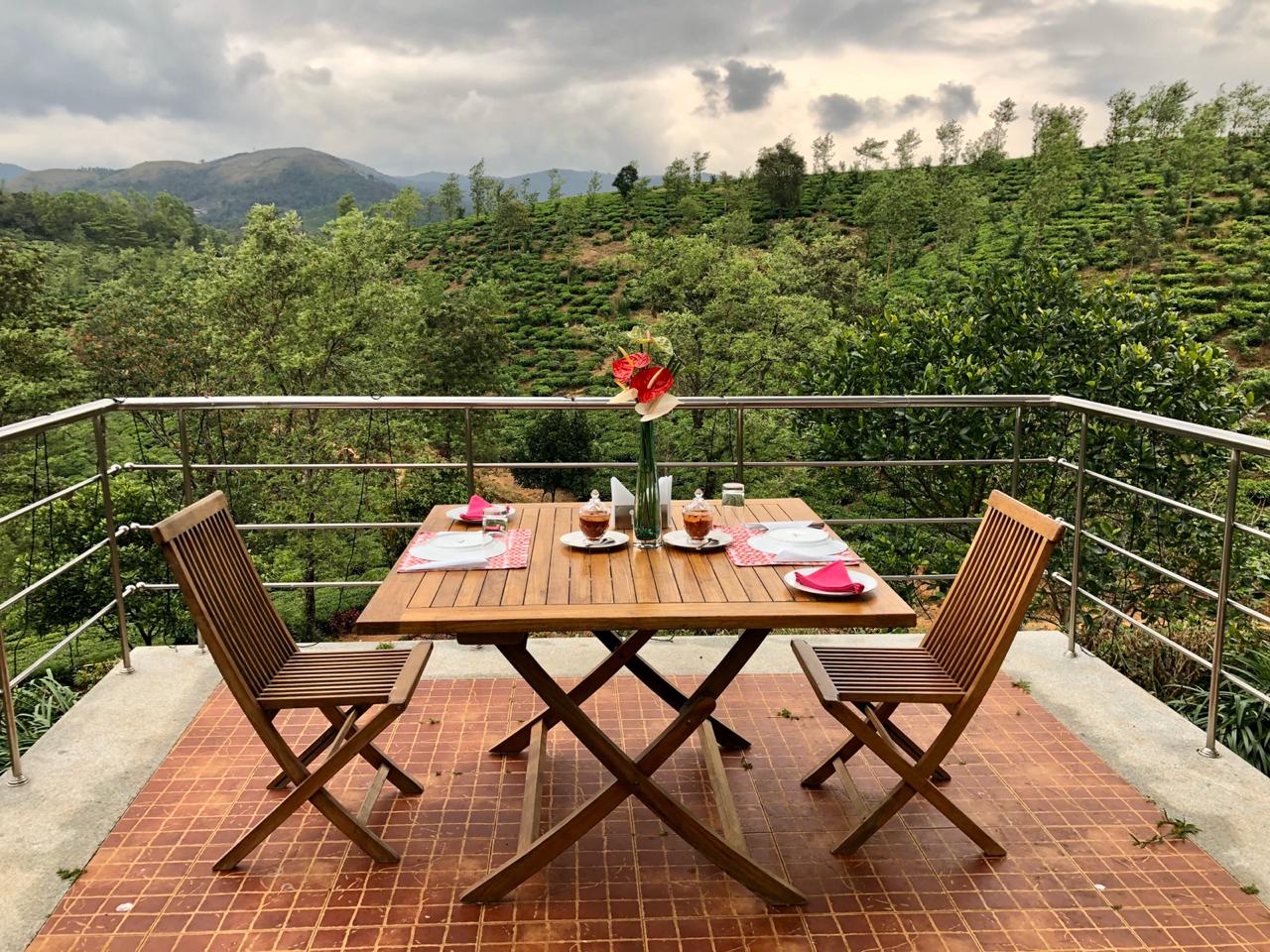 Terrace table for two set against sweeping tea plantation views