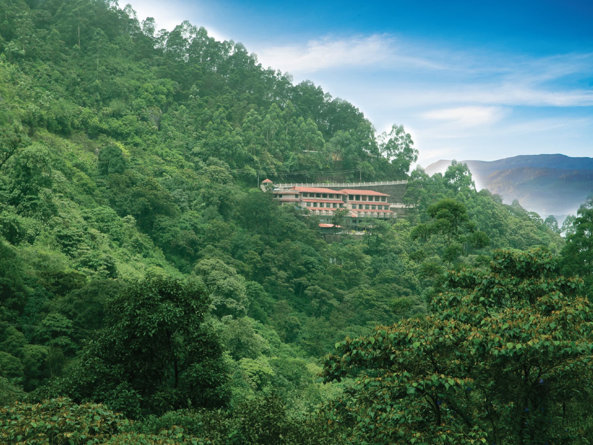 Abad Copper Castle amid forested hills, Munnar