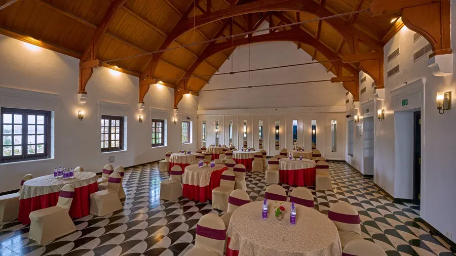 Timber-trussed banquet hall set with round tables