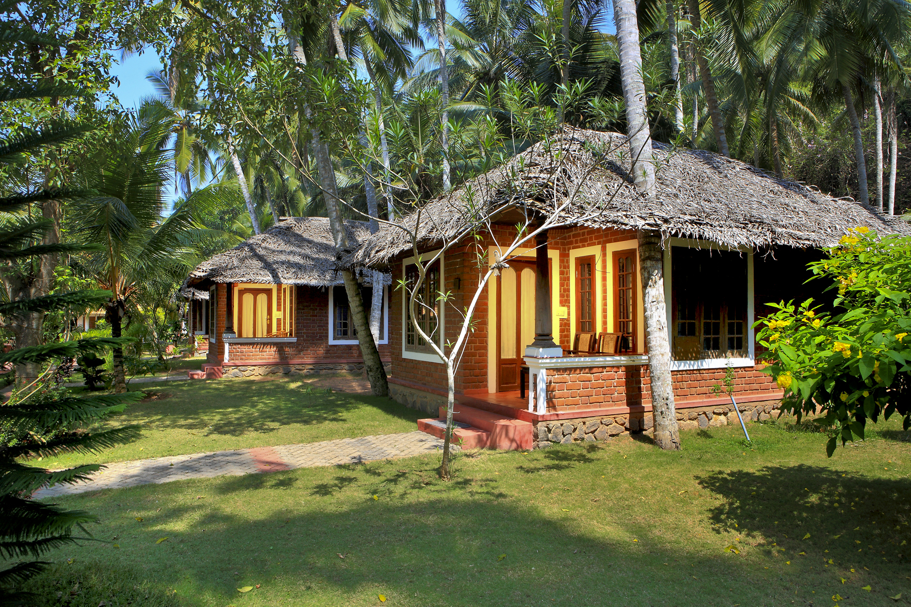 Thatched-roof brick cottages with verandah seating