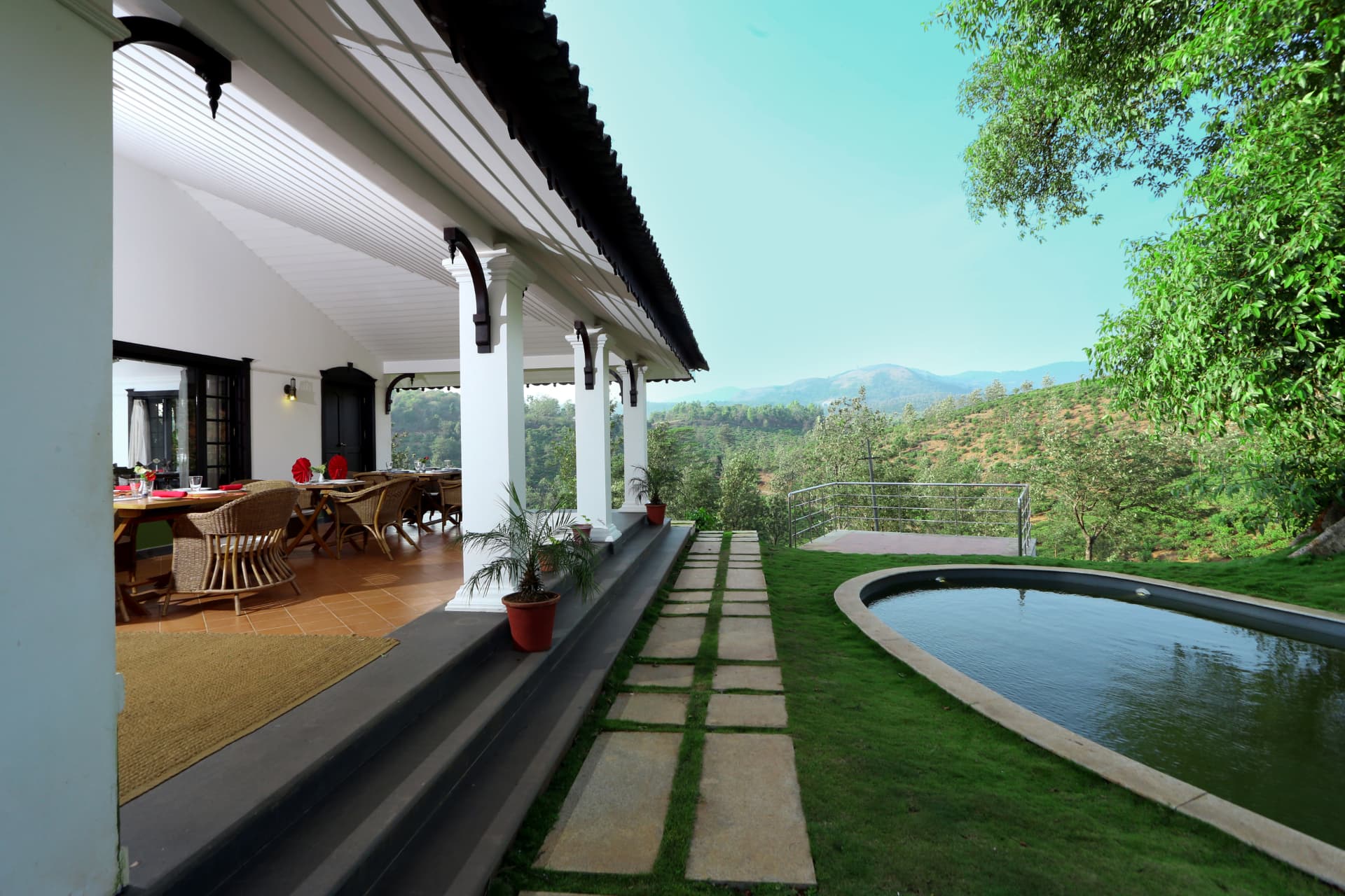 Villa verandah dining beside a private pool with plantation views