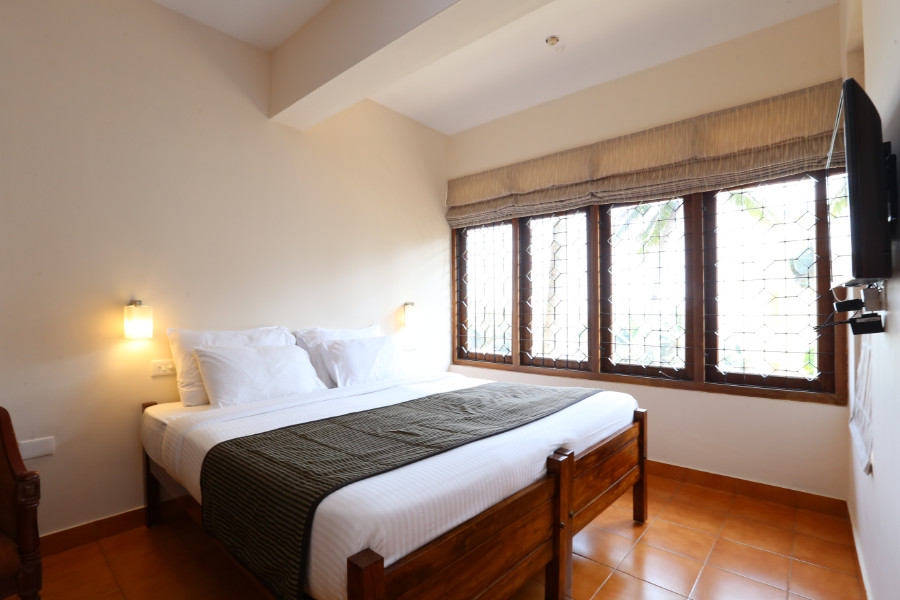 Deluxe Room at Abad Serviced Villas with king bed and LED television