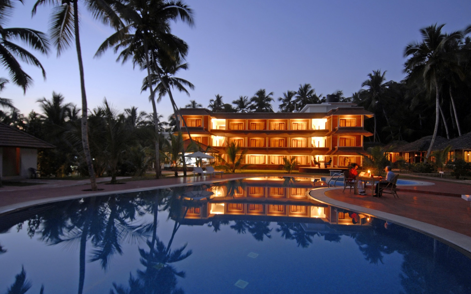 Abad Harmonia illuminated at dusk reflected in the swimming pool