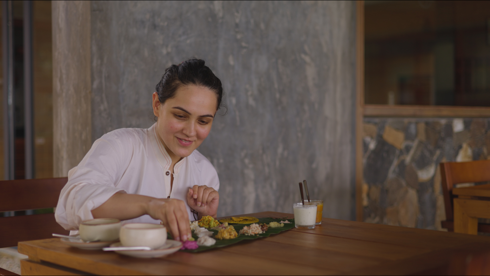 Guest eating a raw sadhya served on a banana leaf at Prakriti Shakti, Panchalimedu
