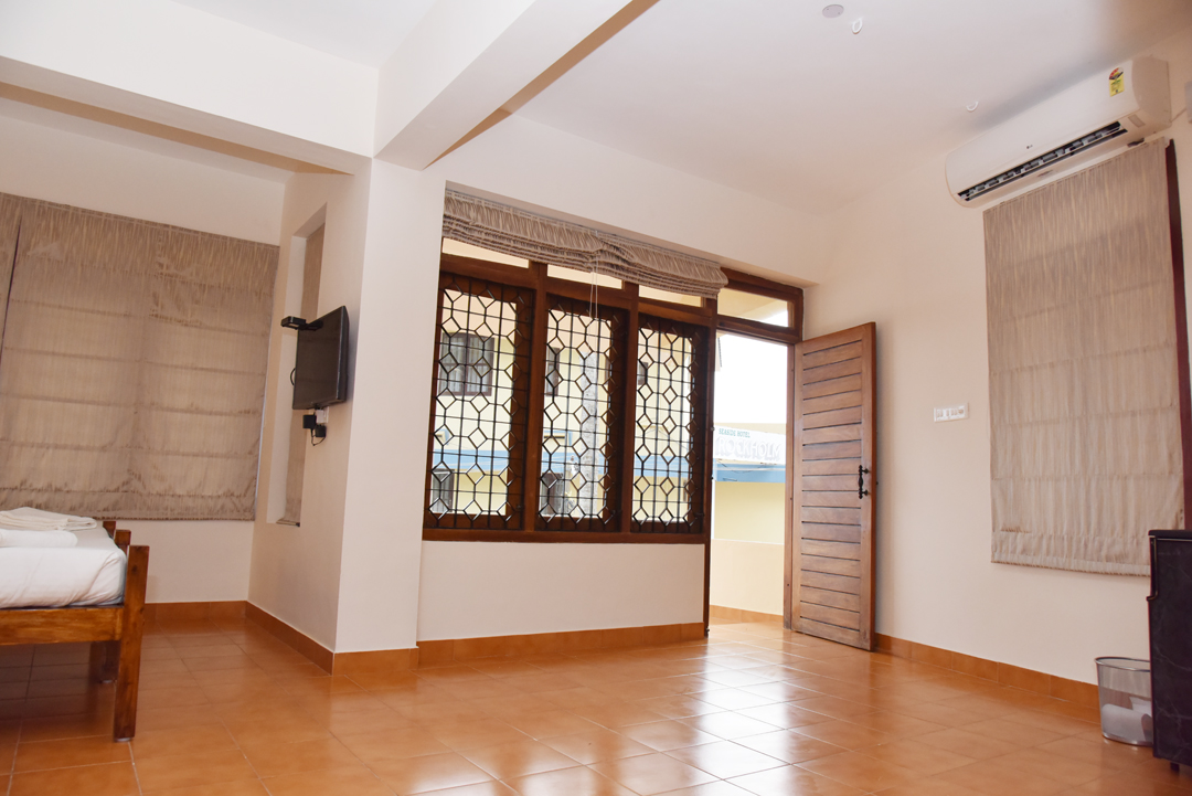Spacious guest room interior at Abad Serviced Villas with stained-glass windows opening to a terrace