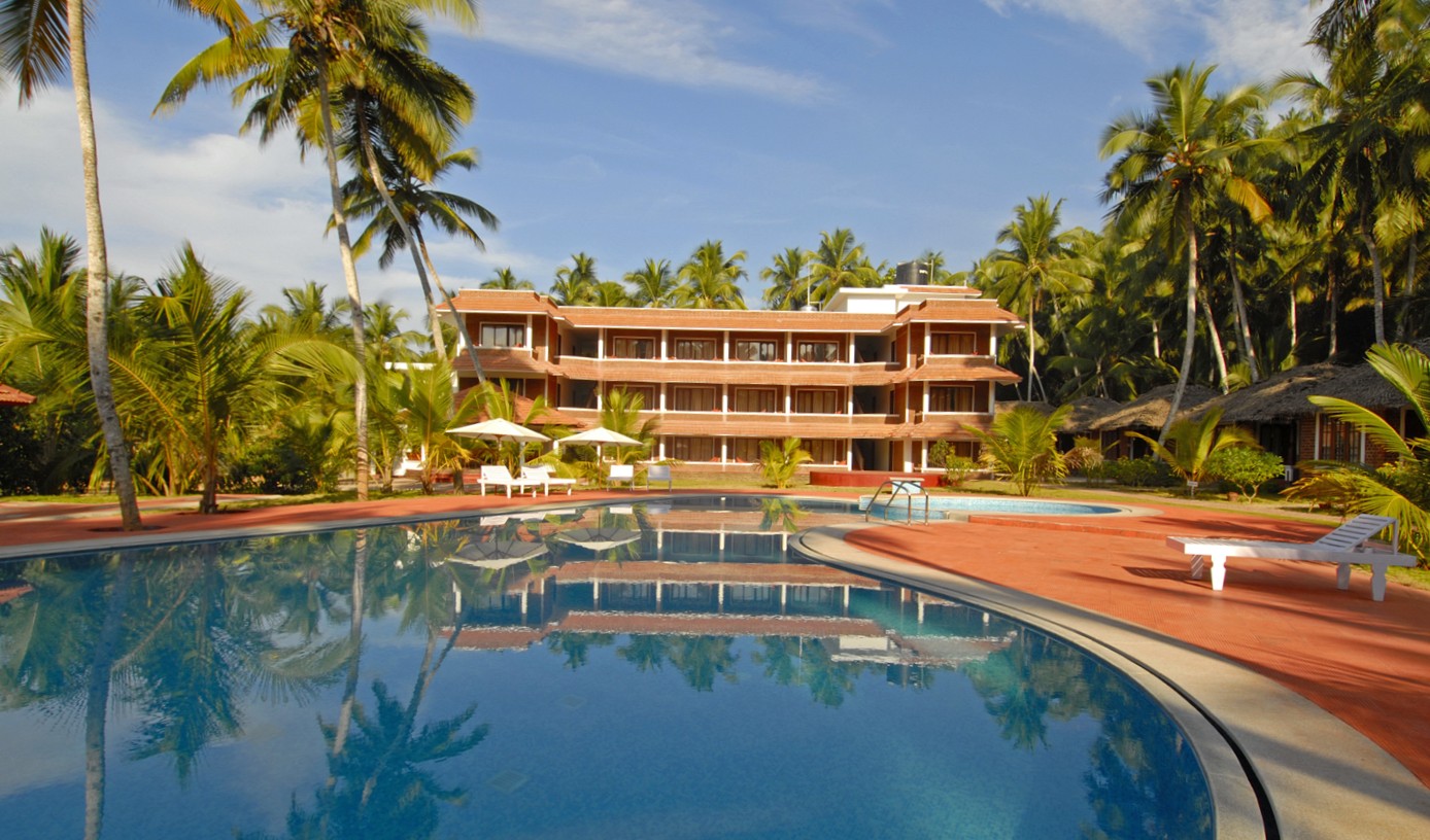 Abad Harmonia resort building and pool seen across the gardens