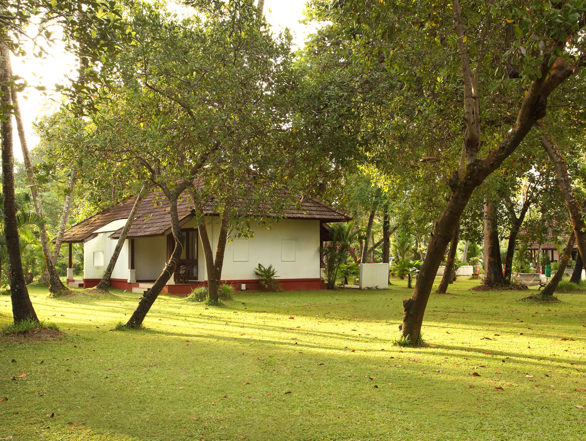 Kerala-style garden cottage beneath shady trees